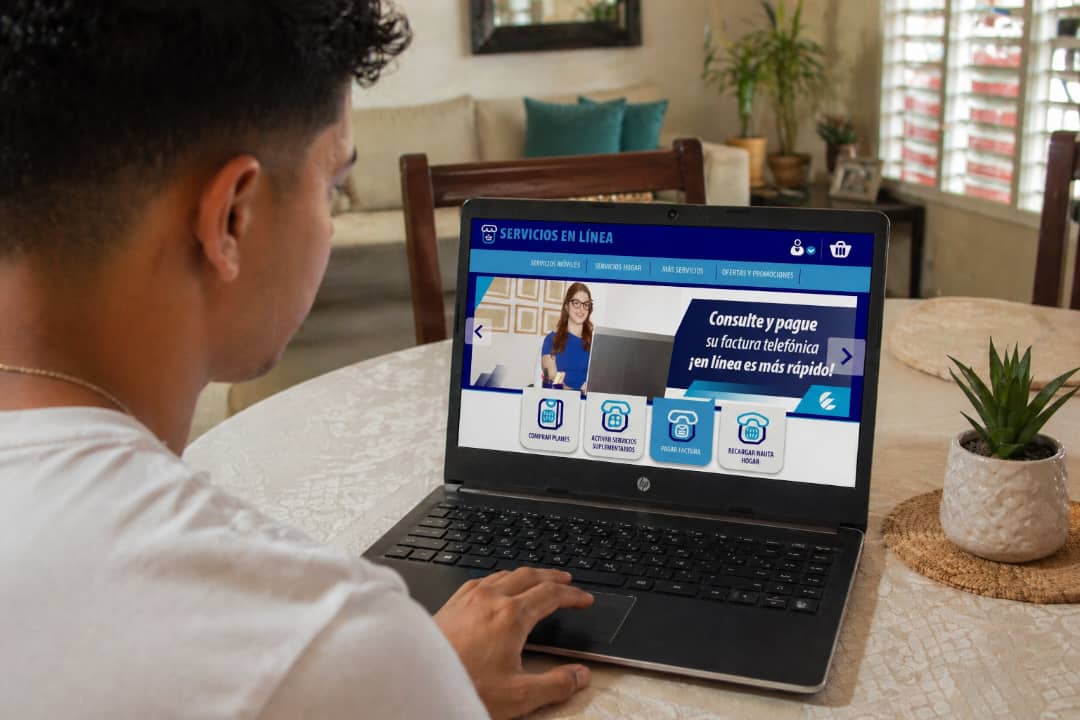 Jóven con laptop y en la pantalla Servicios en Línea